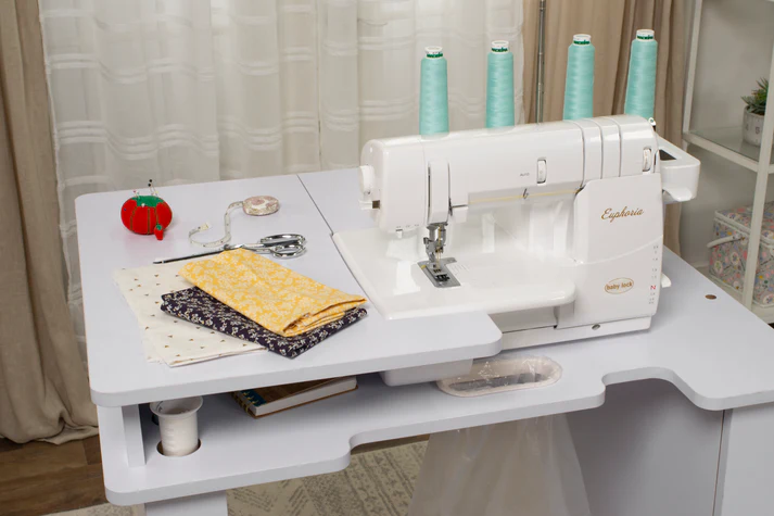 Baby Lock serger sewing machine on a workstation with fabric and sewing tools