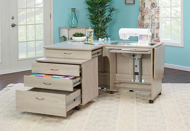 Spacious wooden sewing cabinet with multiple open drawers and a built-in sewing machine